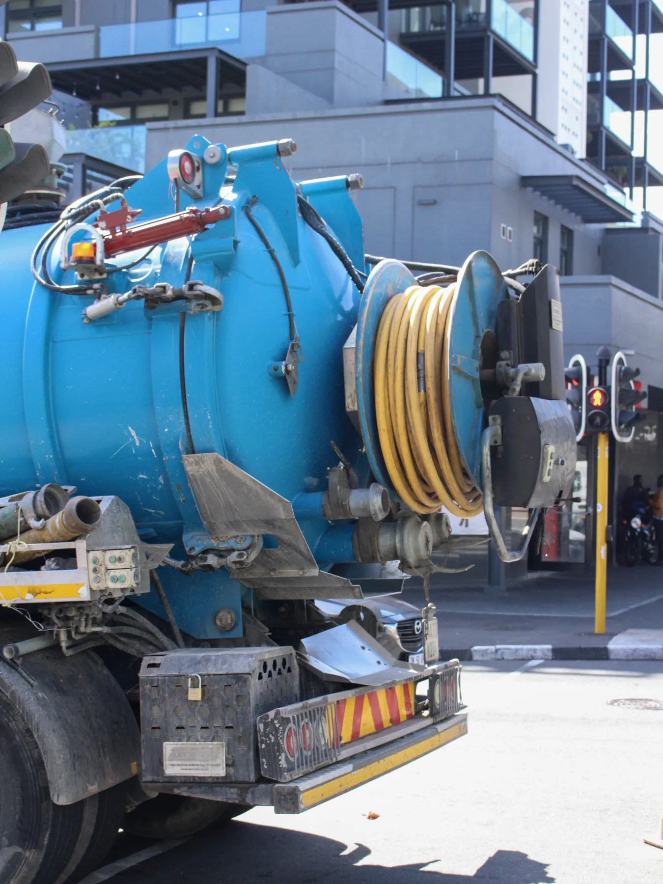 Rear of a combination truck with jetting reels on a city street