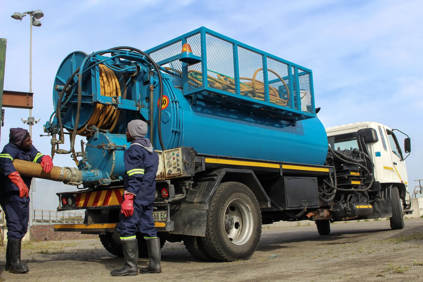 Ramatini crew coupling the suction hose to a vacuum tanker
