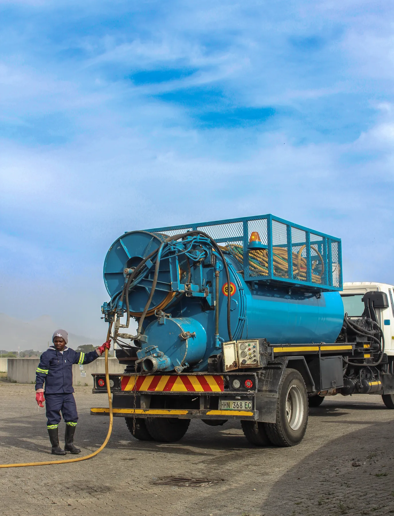 Crew member hosing down beside a tanker