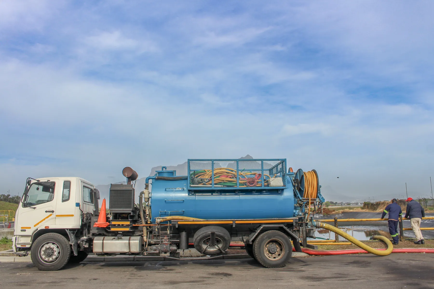 Vacuum tanker at a treatment works with two crew members walking alongside