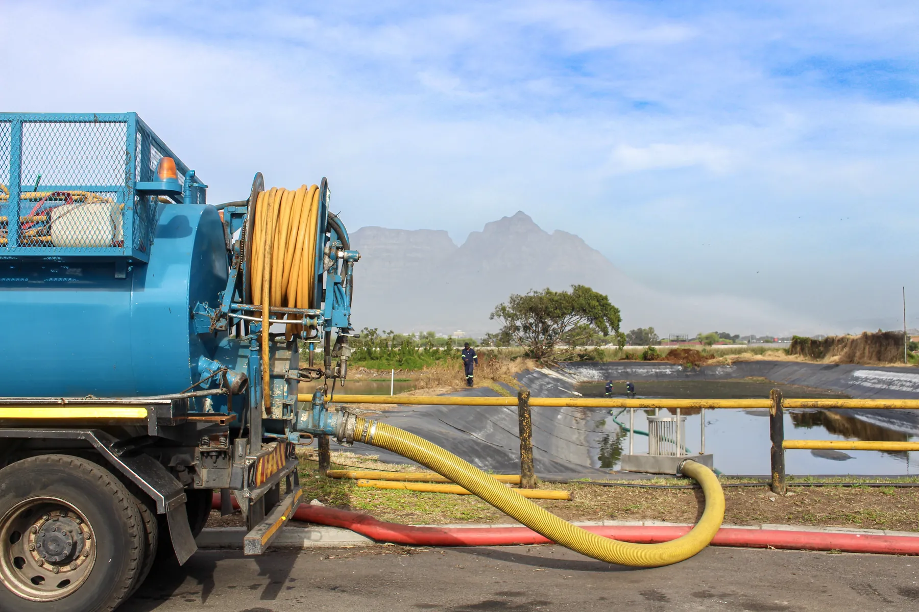 Vacuum tanker with its suction line run out, Table Mountain in the background