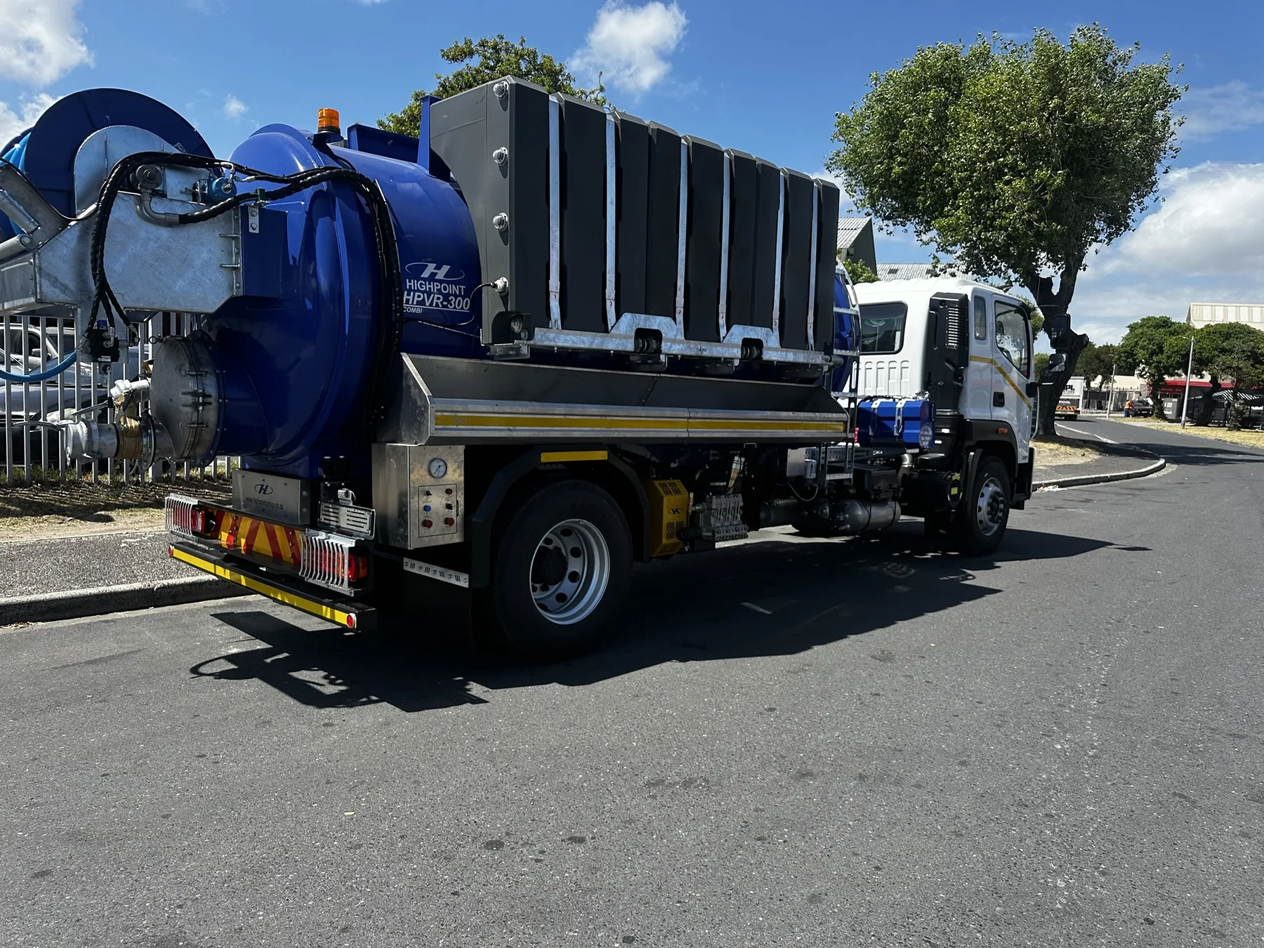 Rear of a combination super sucker showing the suction door, control panel and hose reel